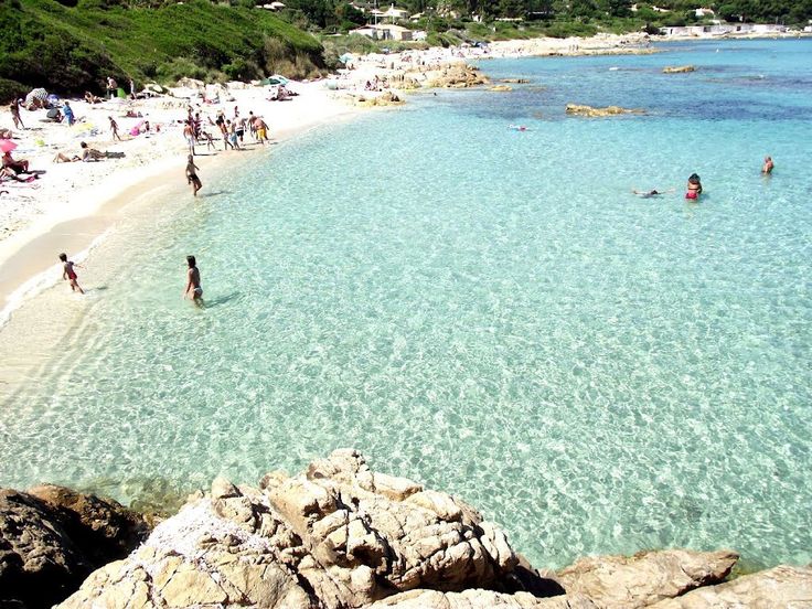 Yacht anchored in a turquoise cove near dramatic coastal cliffs, similar to Corsica's rugged beauty