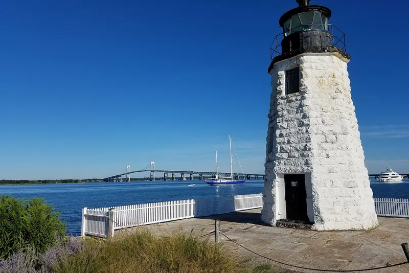 Goat Island lighthouse and the Newport Bridge with yachts in Newport harbor, Rhode Island