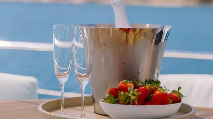 Champagne on ice with strawberries on deck